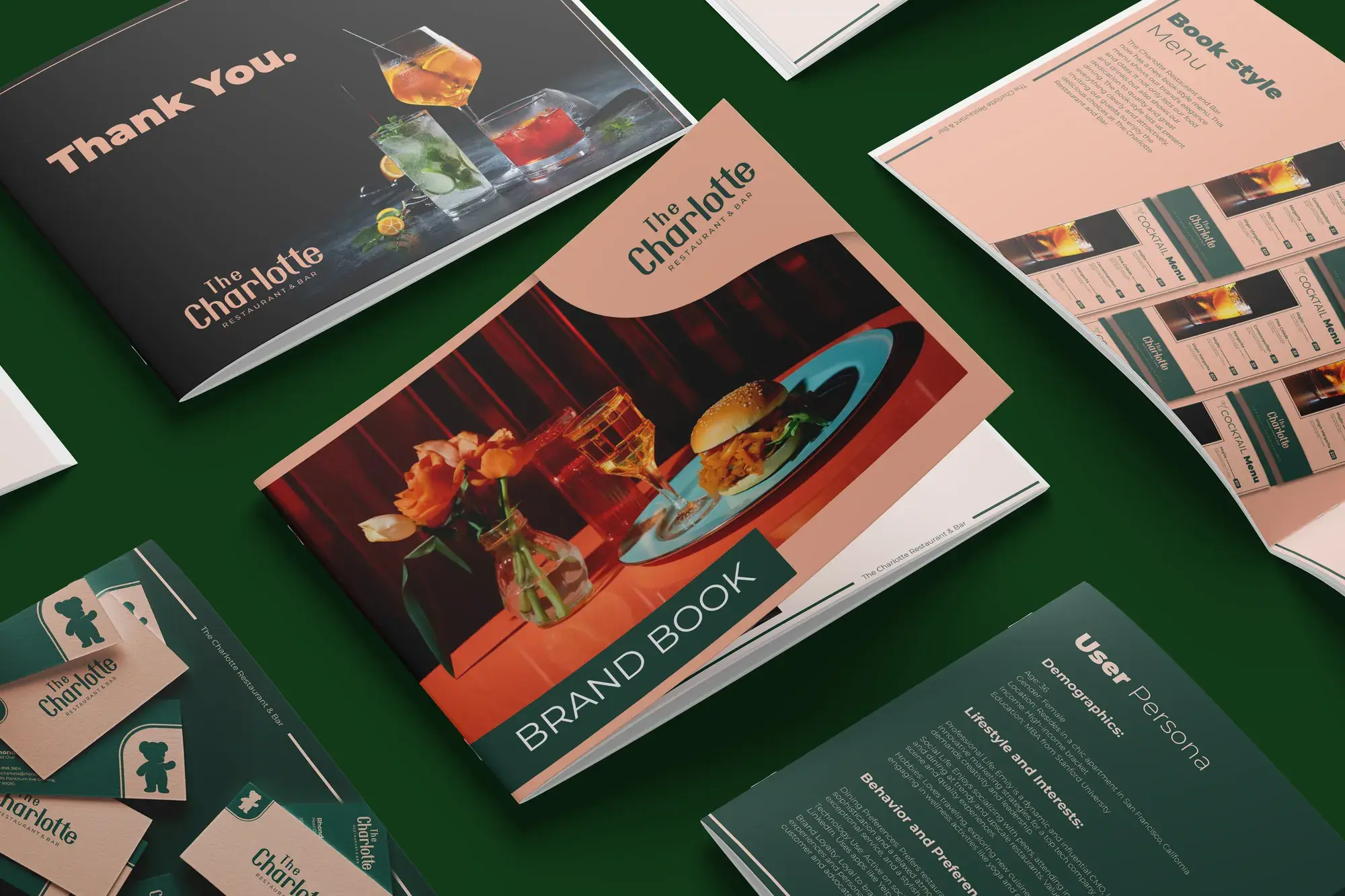 The Charlotte brand book pages spread across a green surface